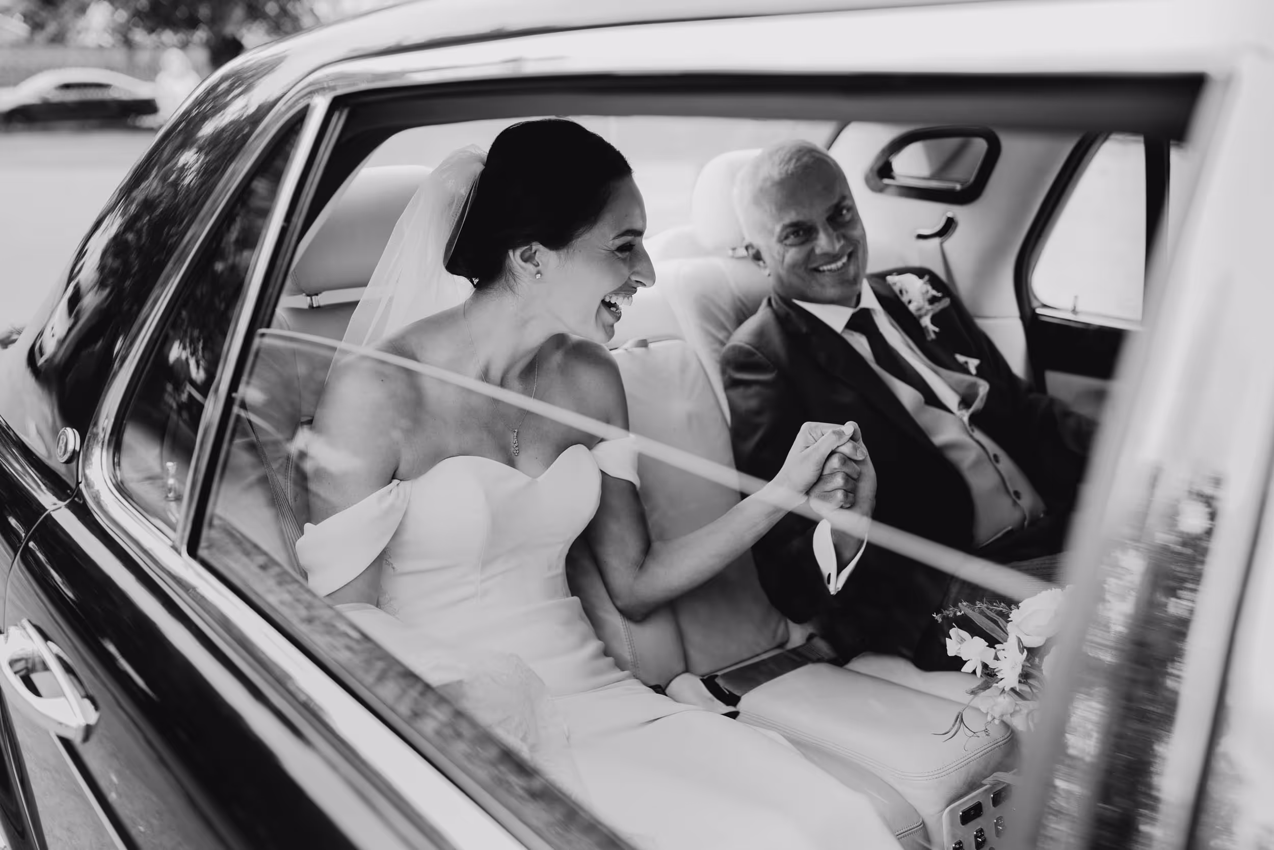 bride and dad arriving at church as he holds her hand