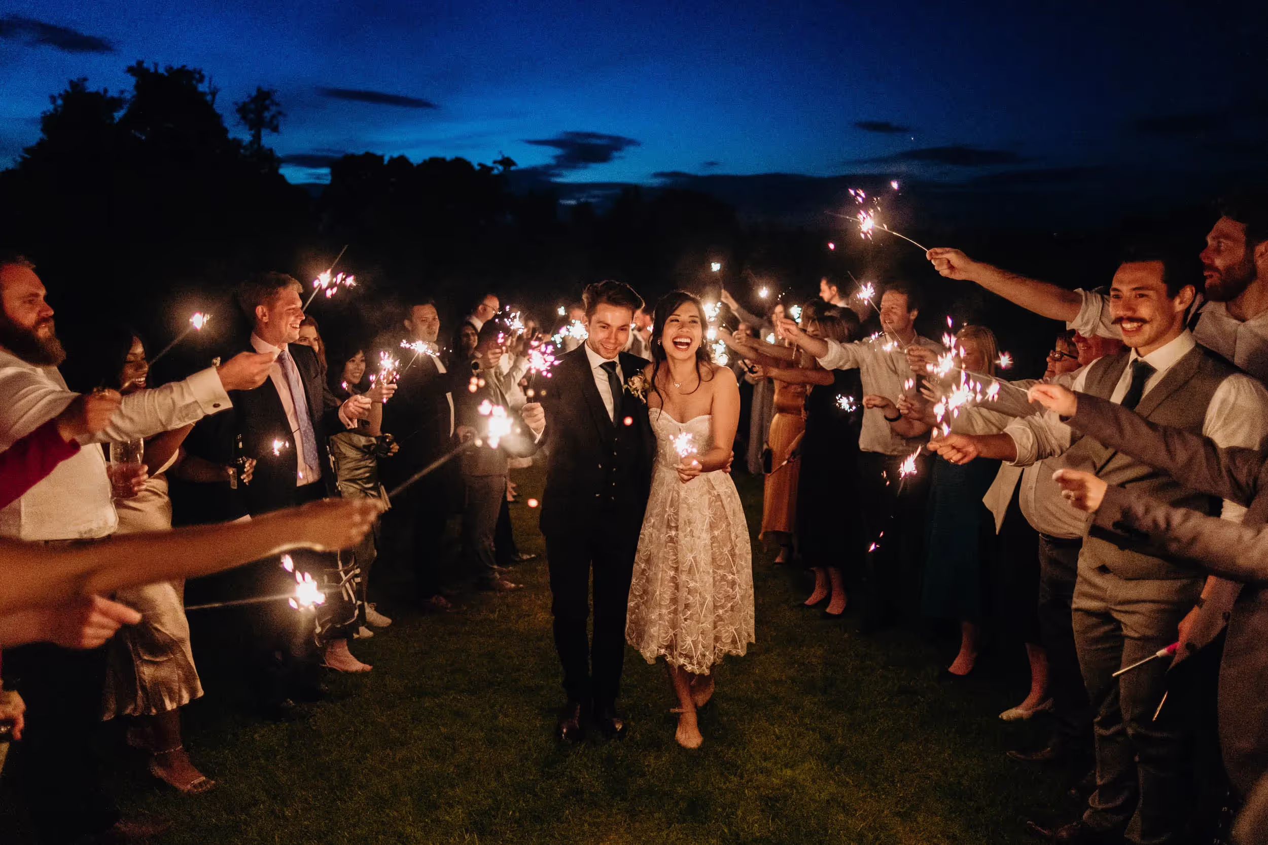 sparkler wedding photograph of couple and their guests with deep blue sky behind